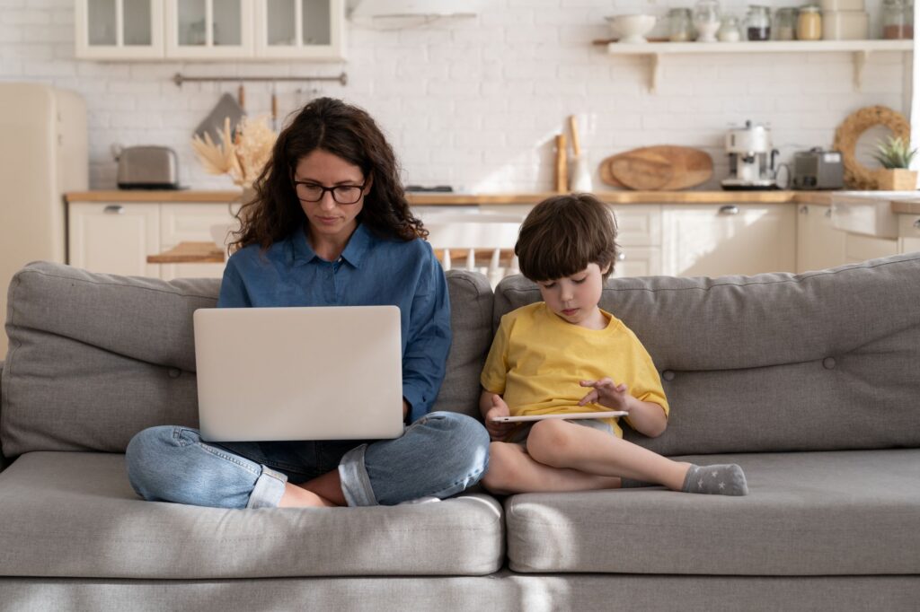 mom searching on computer with child by her